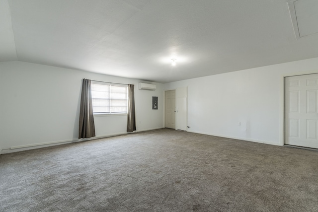 unfurnished room featuring carpet flooring, vaulted ceiling, and a wall mounted AC