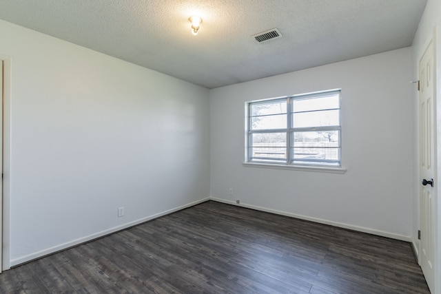 empty room with a textured ceiling and dark wood-type flooring