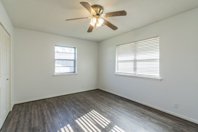 empty room with ceiling fan and dark hardwood / wood-style flooring