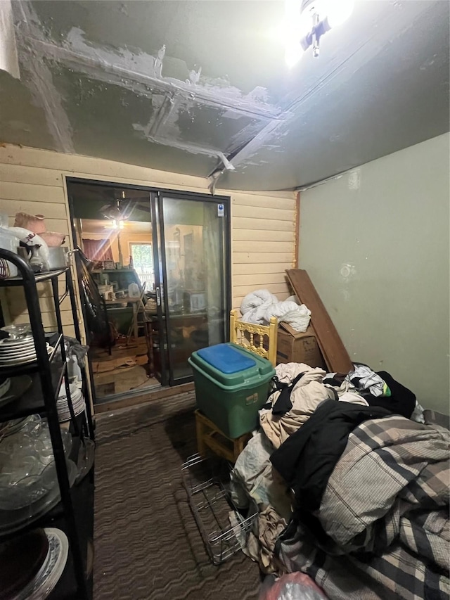 miscellaneous room featuring carpet and wooden walls