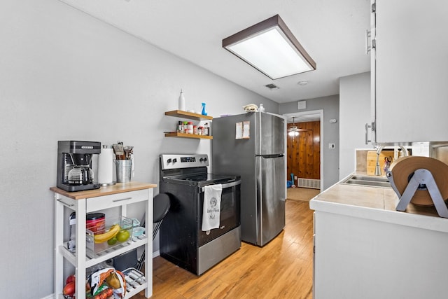 kitchen with white cabinetry, sink, stainless steel appliances, and light wood-type flooring