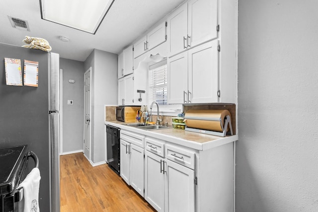 kitchen with dishwasher, sink, range with electric cooktop, light hardwood / wood-style floors, and white cabinetry