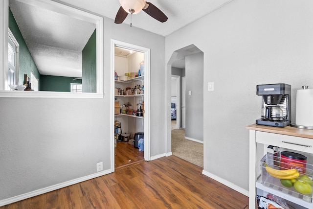 corridor with a textured ceiling and dark hardwood / wood-style floors