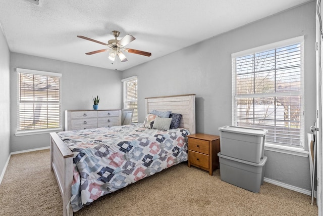 carpeted bedroom featuring multiple windows, ceiling fan, and a textured ceiling