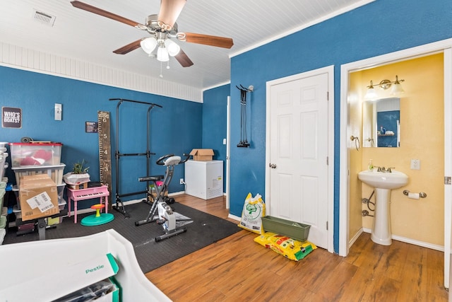 exercise area featuring ceiling fan, sink, and hardwood / wood-style flooring