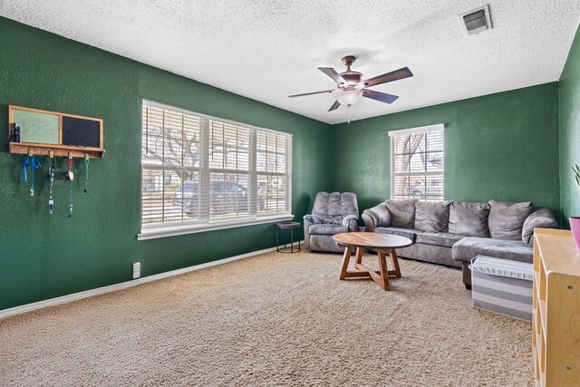 living room with ceiling fan, carpet, and a textured ceiling