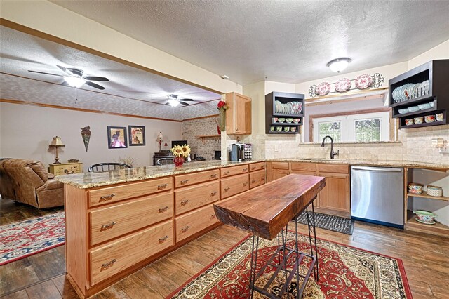 kitchen featuring light stone counters, ceiling fan, dark wood-type flooring, and a textured ceiling