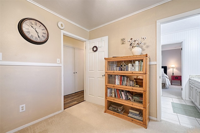 corridor featuring light colored carpet, ornamental molding, and baseboards