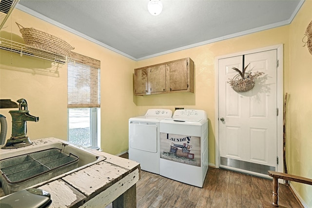 laundry room featuring washing machine and dryer, crown molding, cabinets, and dark hardwood / wood-style floors