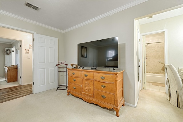 bedroom with light carpet, ensuite bath, and crown molding