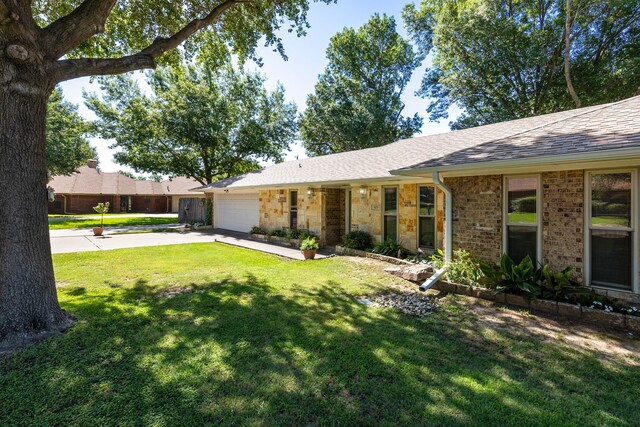 ranch-style home with roof with shingles, stone siding, driveway, a garage, and a front yard