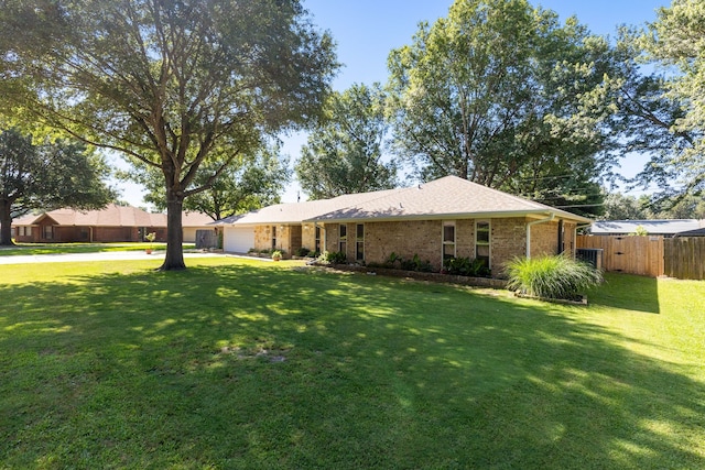 exterior space featuring fence, brick siding, concrete driveway, a garage, and a lawn