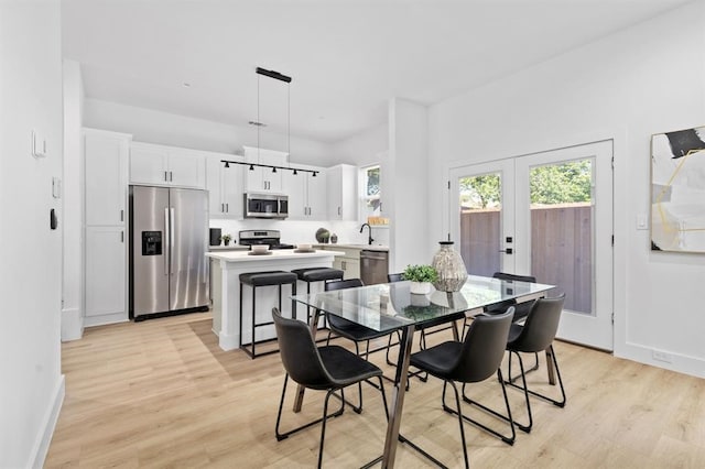 dining room featuring french doors, light hardwood / wood-style floors, and sink