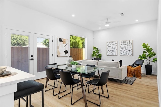 dining space featuring ceiling fan, light wood-type flooring, and french doors