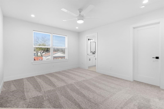 unfurnished bedroom with ceiling fan, light carpet, and connected bathroom