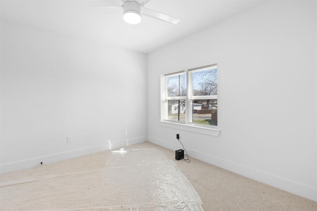 carpeted spare room with ceiling fan