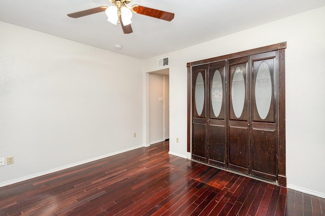 unfurnished bedroom featuring ceiling fan, a closet, and dark hardwood / wood-style flooring