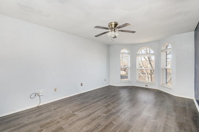 spare room with dark hardwood / wood-style floors and ceiling fan