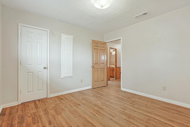 unfurnished bedroom featuring light hardwood / wood-style flooring and a textured ceiling