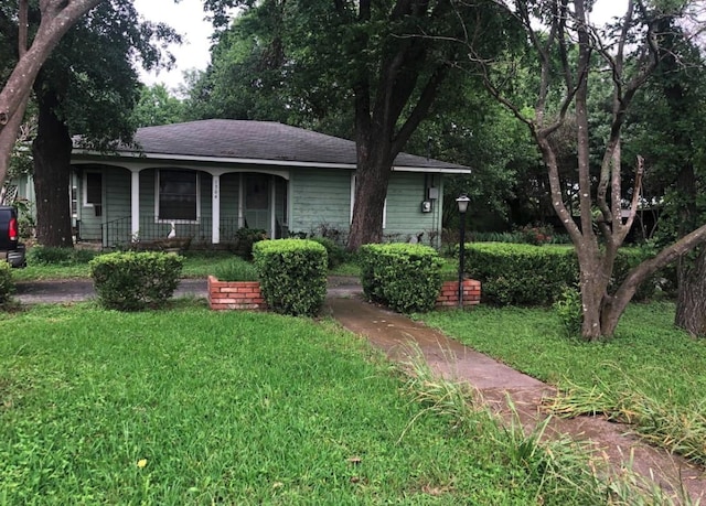 single story home with covered porch and a front yard