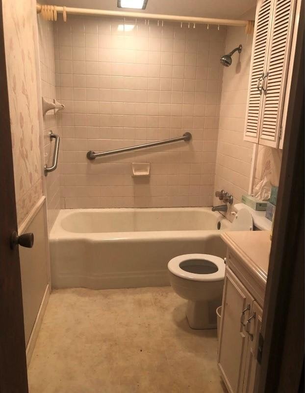 bathroom featuring tub / shower combination, vanity, and toilet