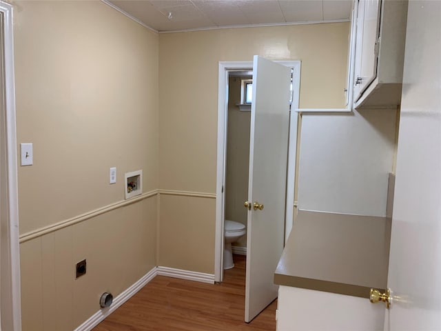 laundry room featuring electric dryer hookup, washer hookup, light hardwood / wood-style floors, and cabinets