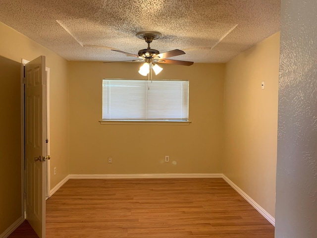 unfurnished room with ceiling fan, light hardwood / wood-style flooring, and a textured ceiling