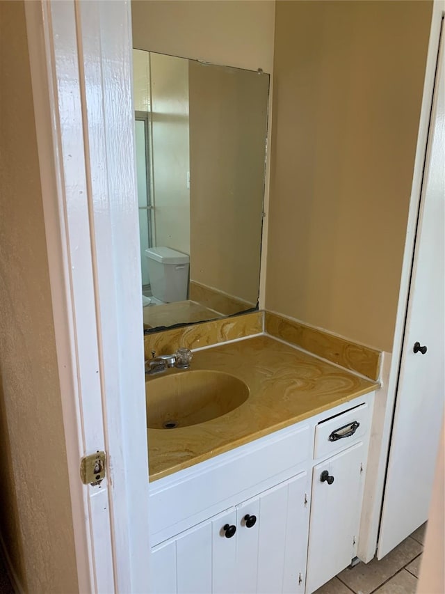 bathroom with vanity, tile patterned floors, and toilet