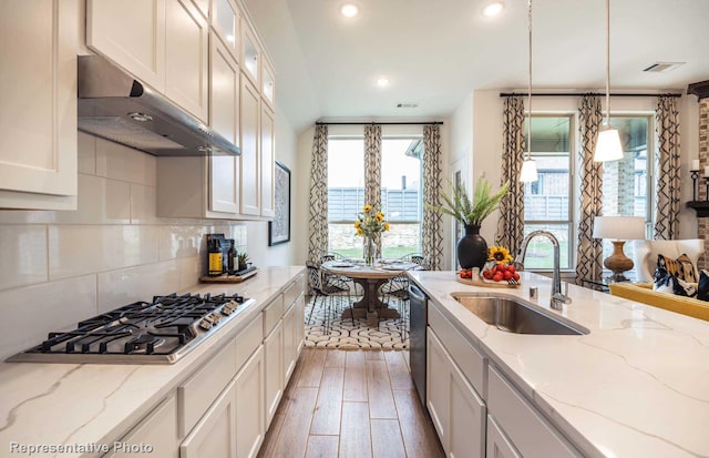 kitchen with white cabinets, appliances with stainless steel finishes, pendant lighting, and sink