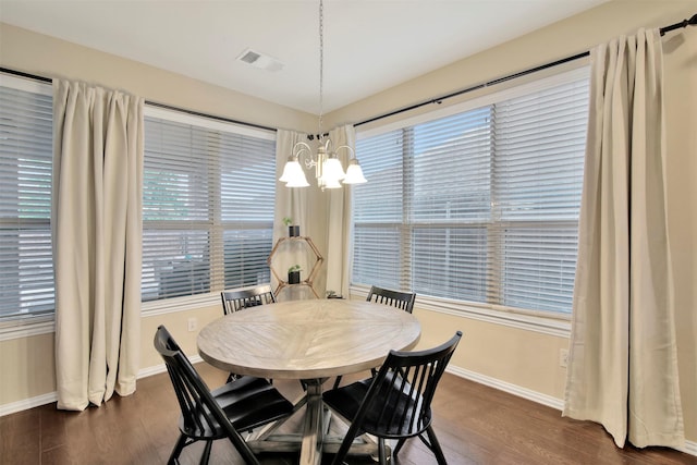 dining room featuring dark hardwood / wood-style floors, a wealth of natural light, and an inviting chandelier