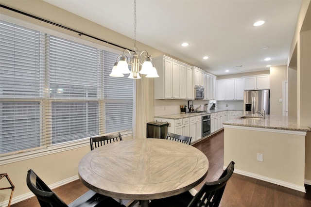 dining room featuring dark hardwood / wood-style floors, an inviting chandelier, and sink