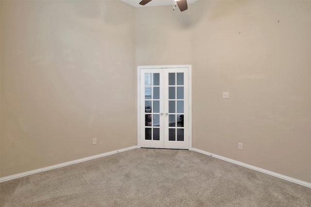 empty room with ceiling fan, french doors, and carpet