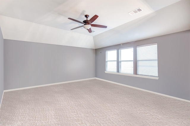 carpeted empty room featuring ceiling fan and vaulted ceiling