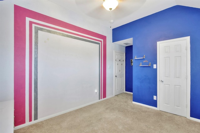 carpeted empty room with ceiling fan and lofted ceiling