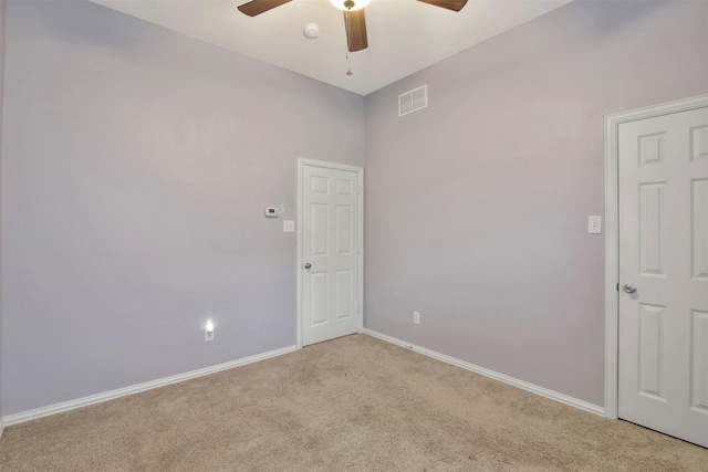 spare room featuring light carpet and ceiling fan