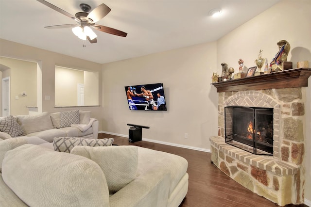 living room with ceiling fan, a fireplace, and dark wood-type flooring