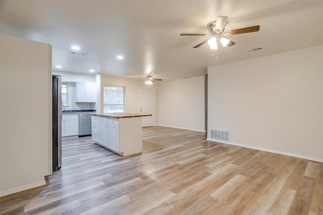 kitchen with light hardwood / wood-style flooring, ceiling fan, appliances with stainless steel finishes, white cabinets, and a kitchen island