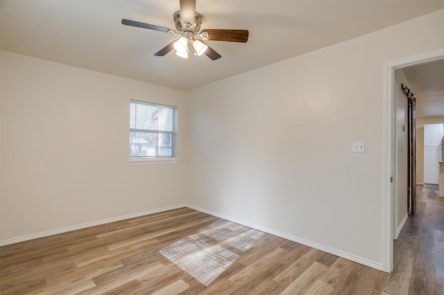 spare room with ceiling fan and light wood-type flooring