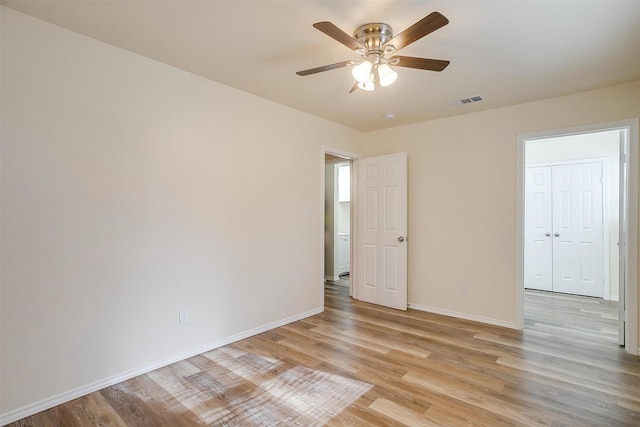 empty room featuring ceiling fan and light hardwood / wood-style floors