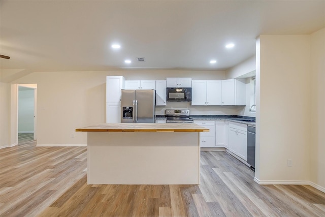 kitchen featuring sink, wooden counters, stainless steel appliances, a center island, and white cabinets