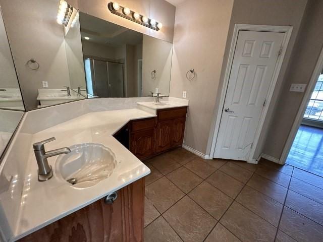 bathroom with walk in shower, vanity, and tile patterned flooring