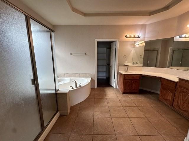 bathroom with tile patterned floors, vanity, independent shower and bath, and a tray ceiling