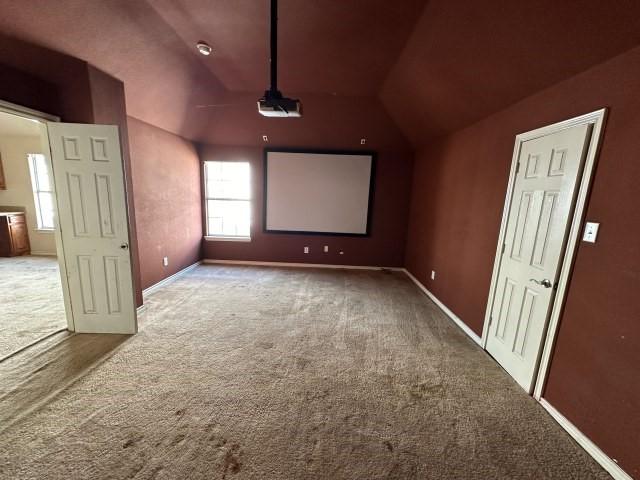 cinema room featuring carpet floors and lofted ceiling