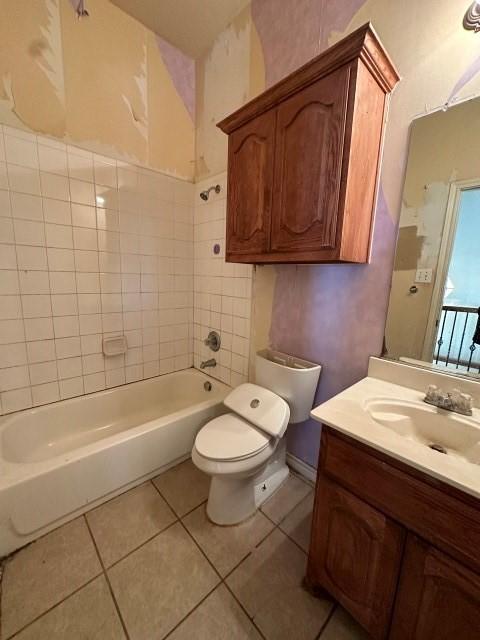 full bathroom featuring tiled shower / bath, vanity, toilet, and tile patterned flooring