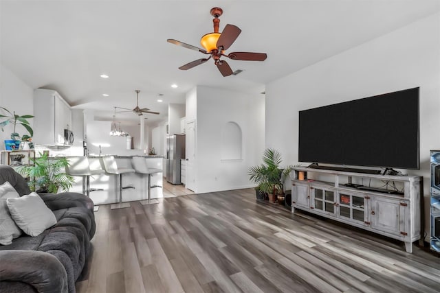 living room featuring wood-type flooring, ceiling fan, and sink