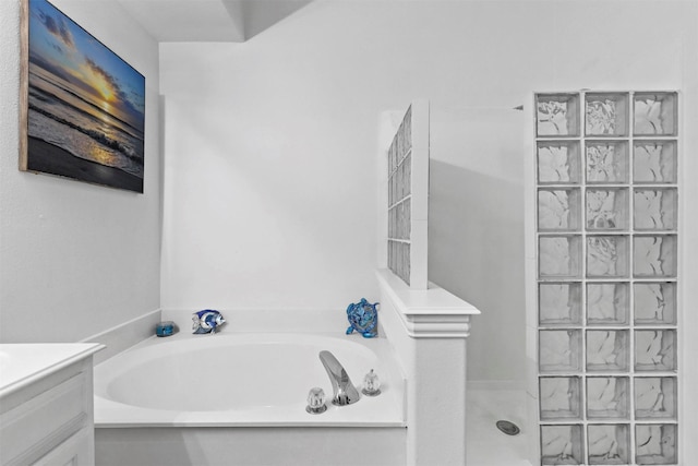 bathroom with vanity and shower with separate bathtub