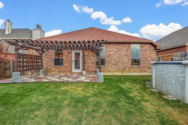 rear view of property featuring a pergola, a patio area, and a yard