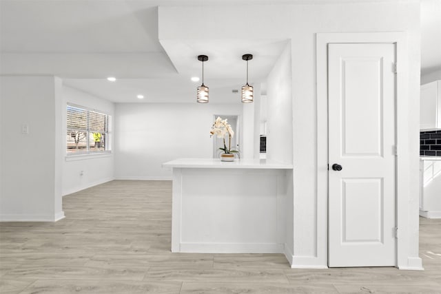 kitchen with pendant lighting, white cabinets, and kitchen peninsula