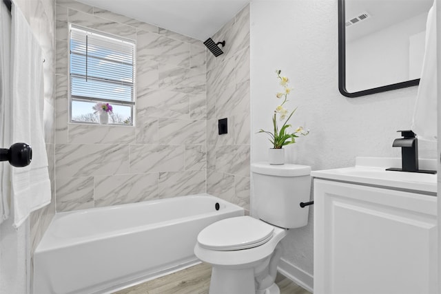 full bathroom with hardwood / wood-style floors, vanity, tiled shower / bath combo, and toilet