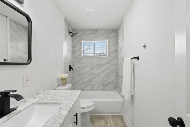 full bathroom with wood-type flooring, vanity, toilet, and tiled shower / bath combo